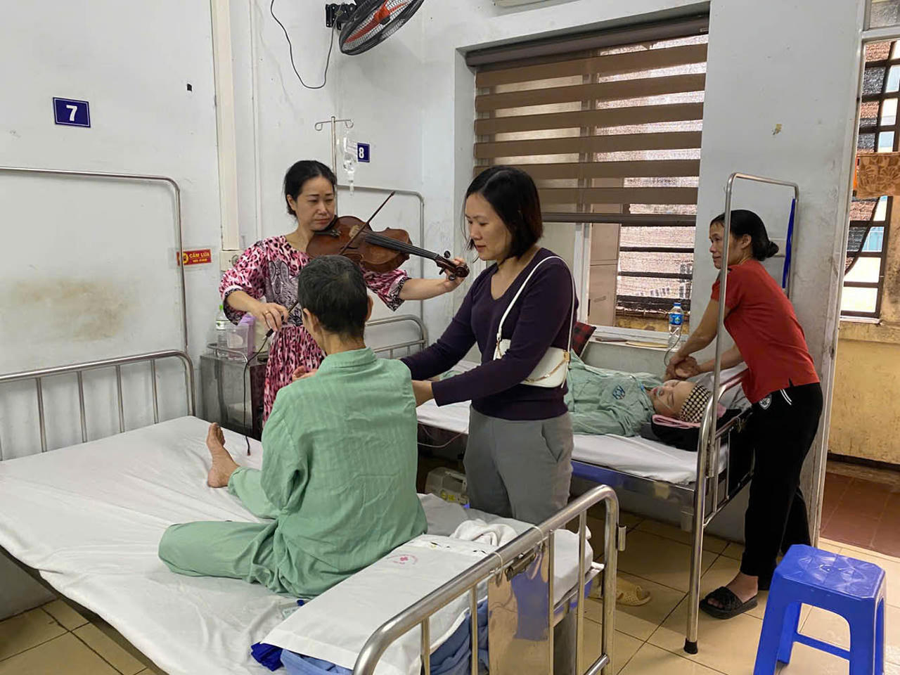 Nghệ sĩ viola Quốc tế Nguyệt Thu tặng bản nhạc êm dịu dành cho bệnh nhân ung thư giai đoạn cuối. (Ảnh: PV)